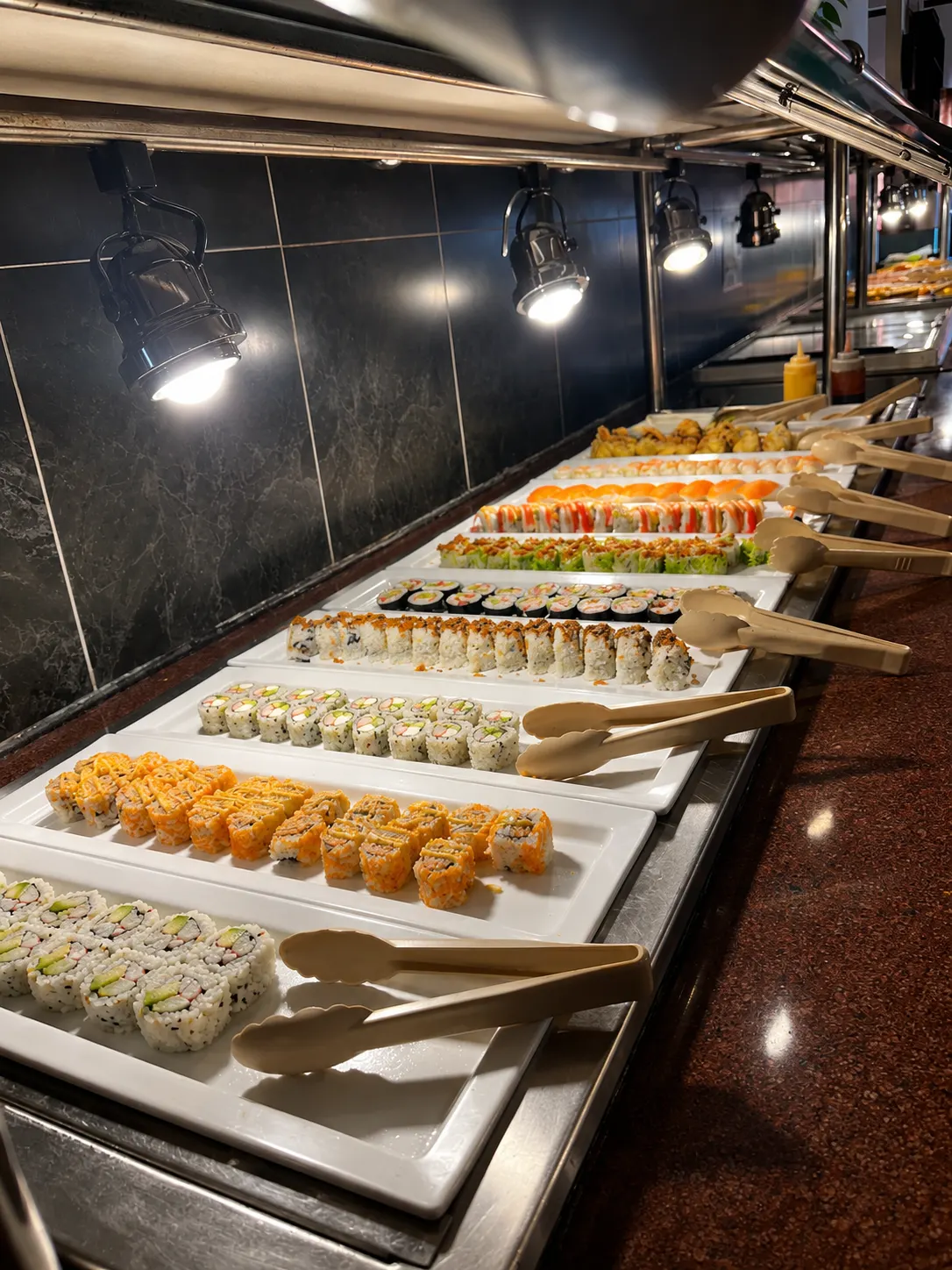Rows of freshly rolled sushi platters on the sushi bar